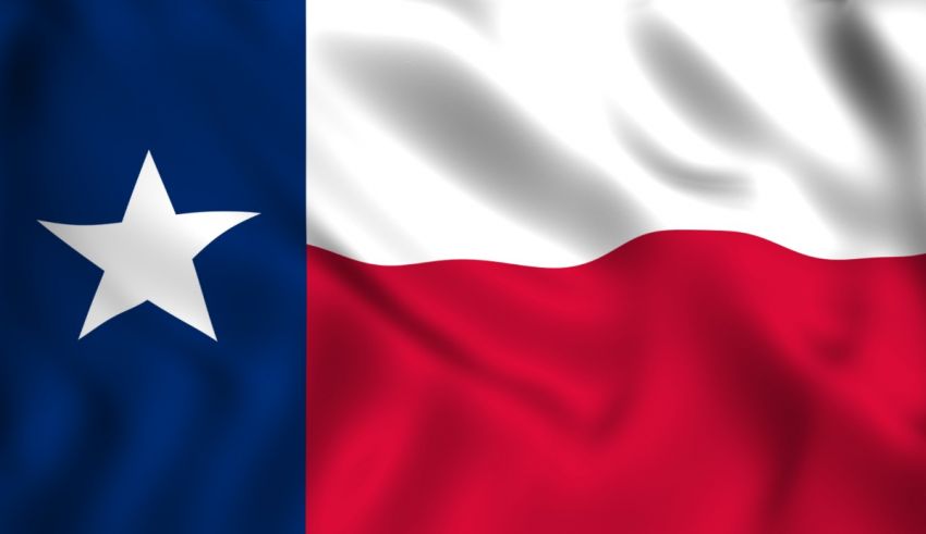 The texas flag is waving in the wind.