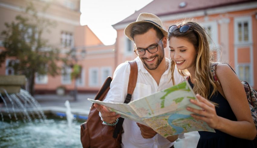 A couple looking at a map in front of a fountain.