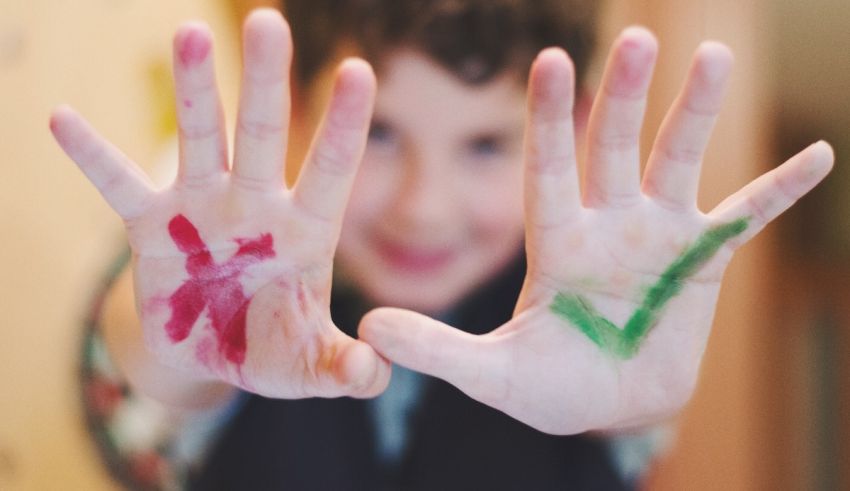 A boy with his hands painted with different colors.