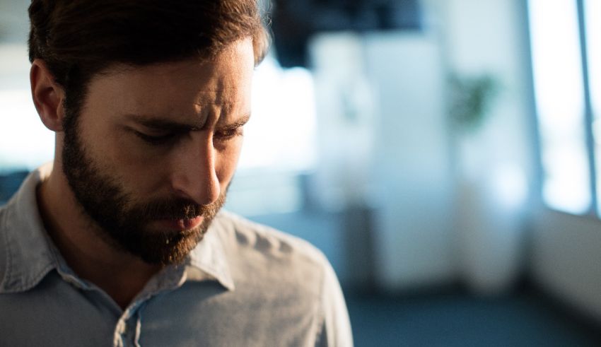 A man with a beard is looking at his phone.
