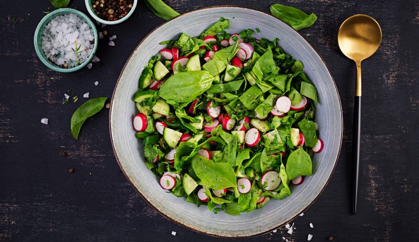 A bowl of salad with radishes and salt.