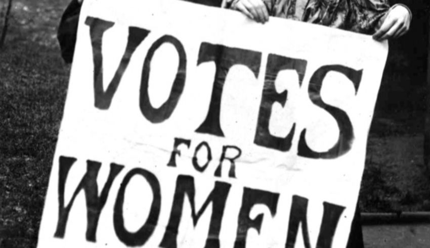 Two women holding up a sign that says votes for women.