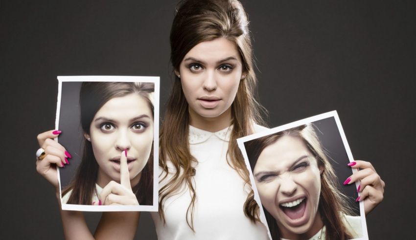 A woman holding up two pictures with different faces on them.