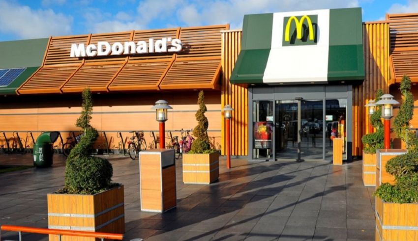 A mcdonald's restaurant with plants in front of it.