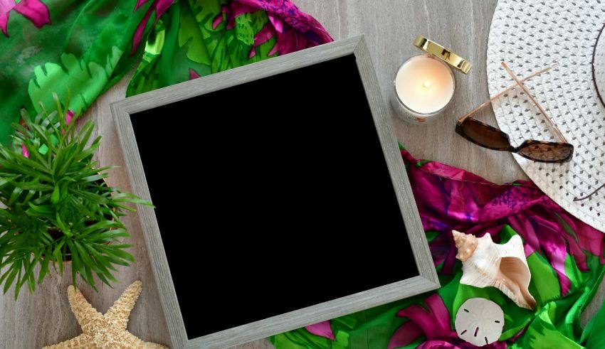 A blank picture frame on a wooden table with a starfish and seashells.