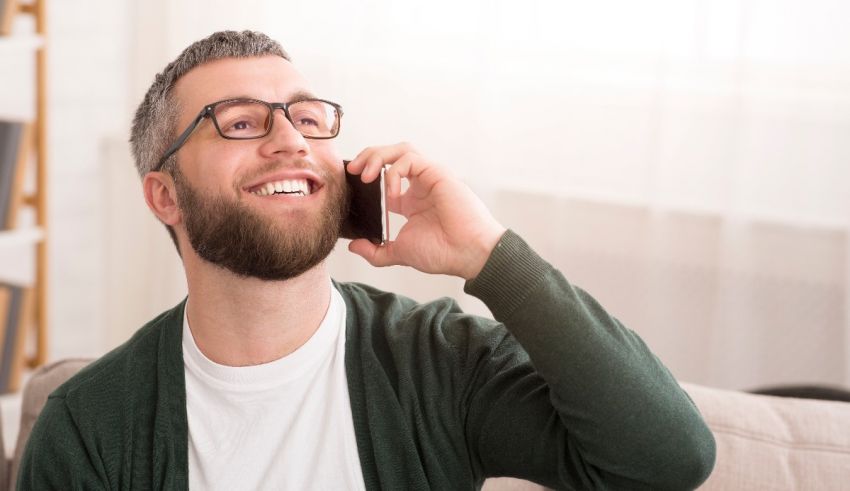 A man talking on a cell phone while sitting on a couch.