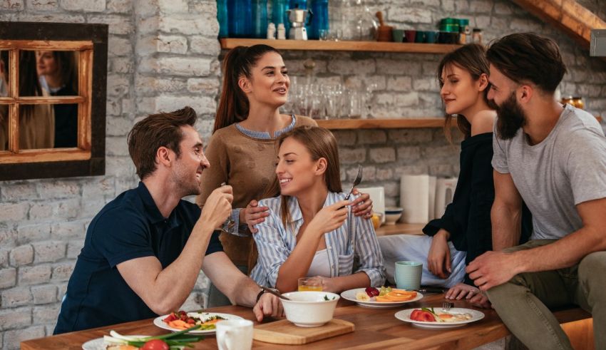 A group of friends eating together in a kitchen.