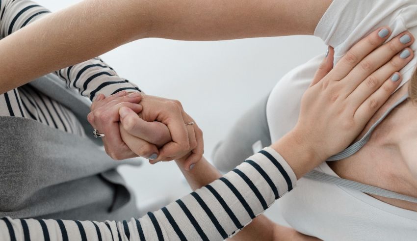 A woman is holding another woman's hand.