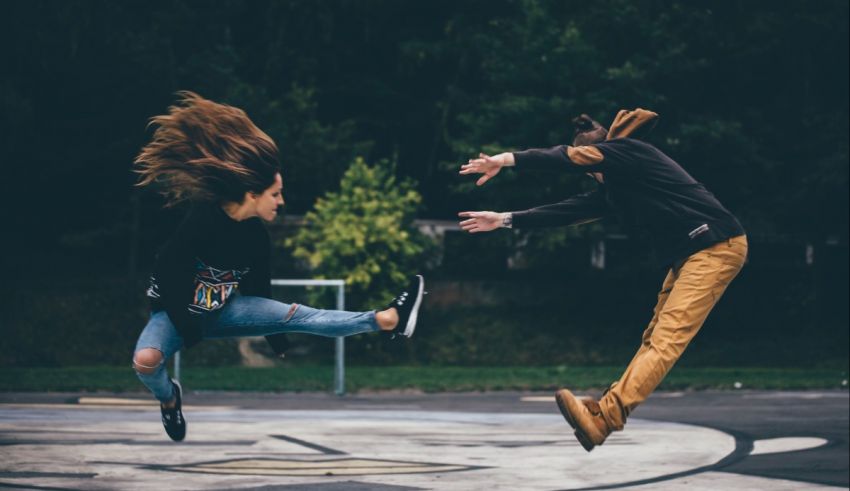 Two people jumping in the air in a park.