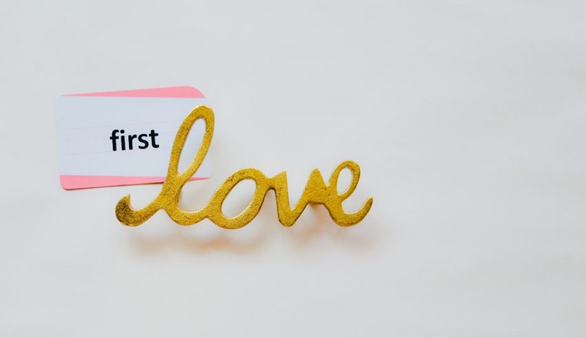 A gold heart with the word first love on it.