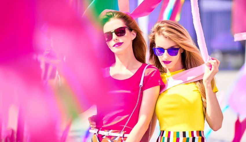 Two women posing in front of colorful balloons.