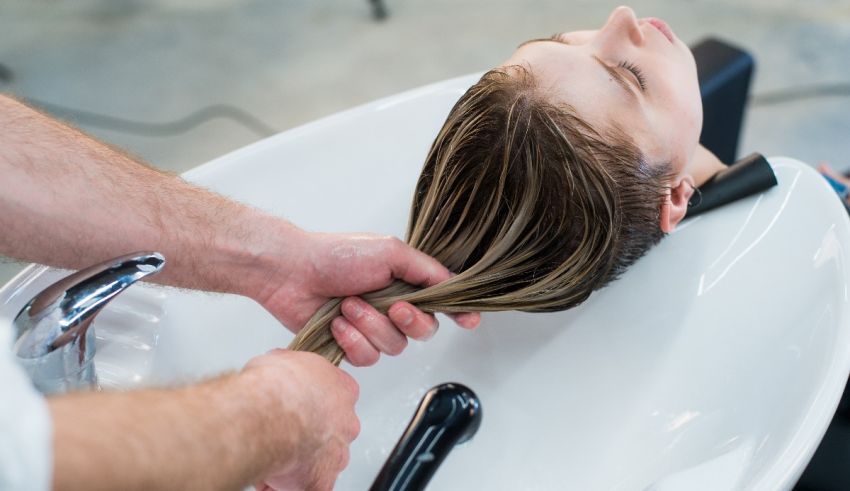 A woman is getting her hair washed in a salon.