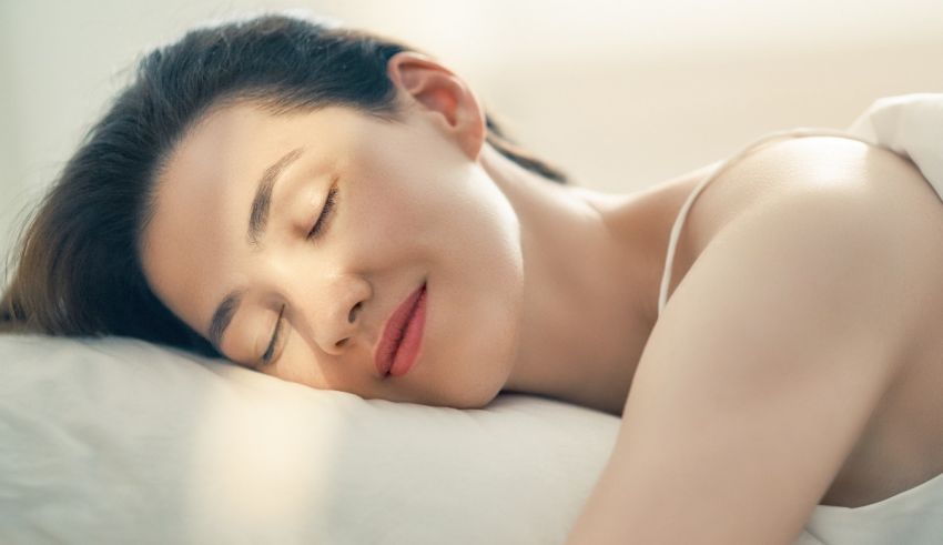 A woman sleeping in bed with her eyes closed.