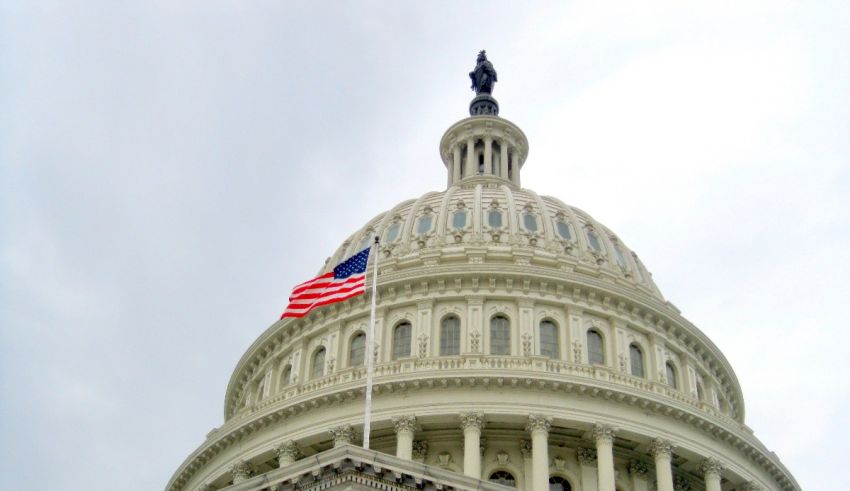 An american flag flies on top of the capitol building.