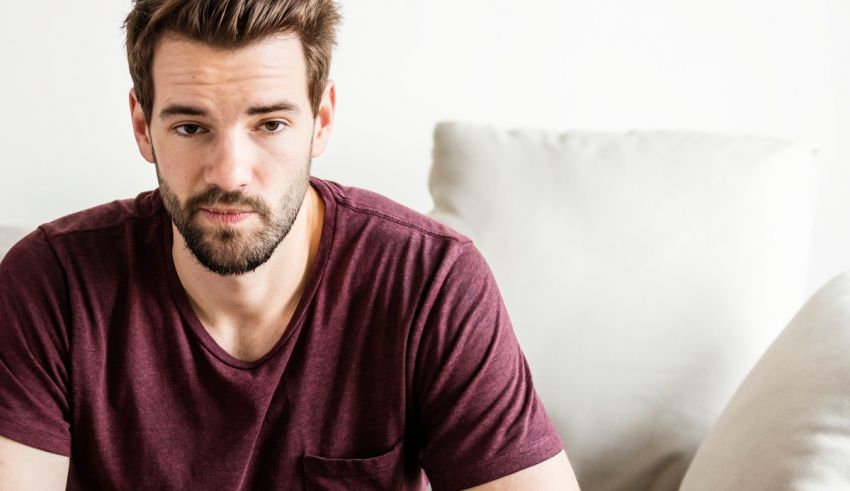 A man with a beard sitting on a couch.