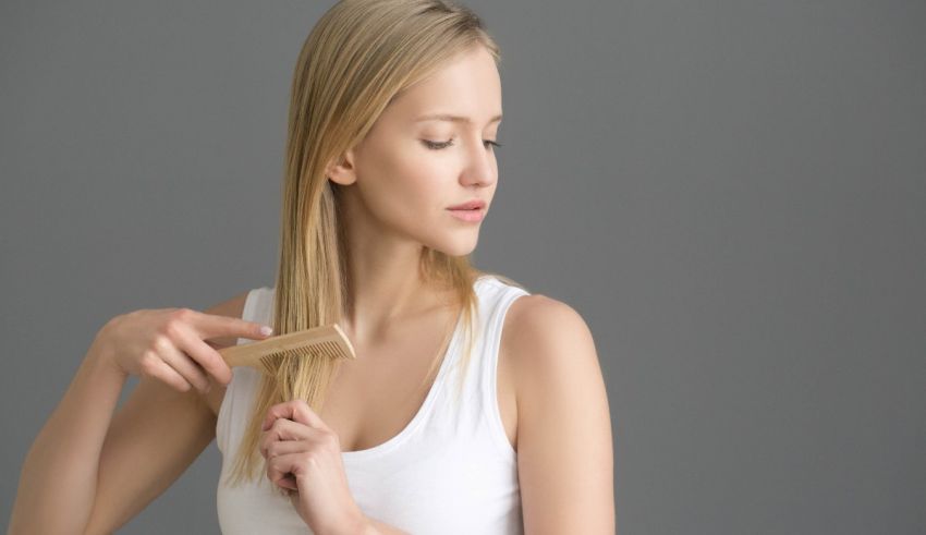 A woman is combing her hair with a comb.