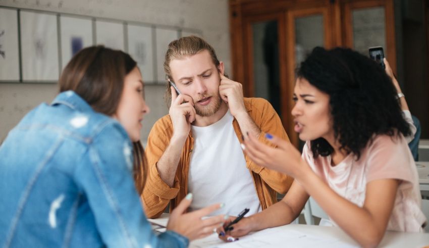 A group of people sitting around a table talking to each other.