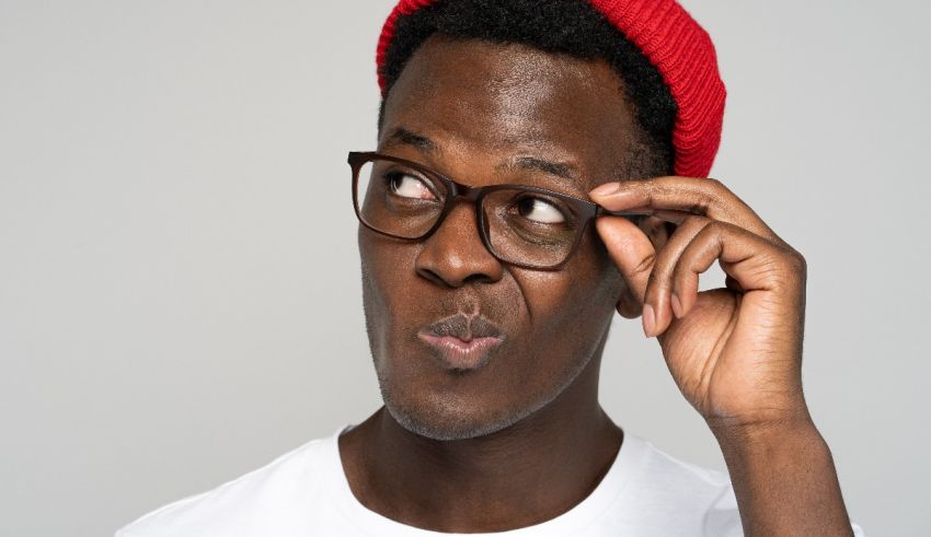 A black man wearing glasses and a red beanie.