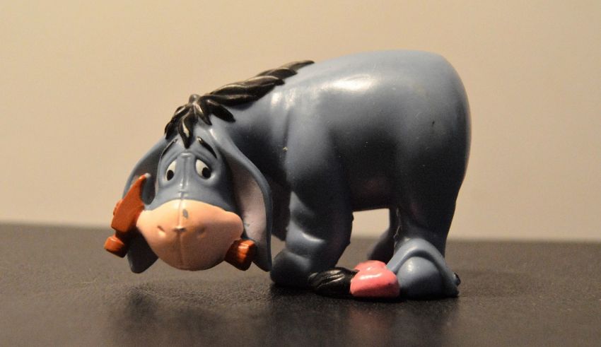 A toy eeyore is standing on top of a table.