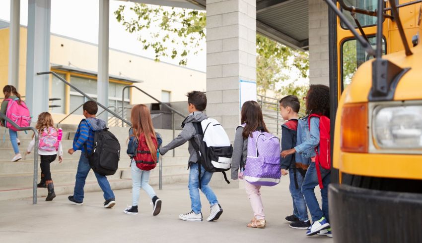 A group of children are walking to a school bus.