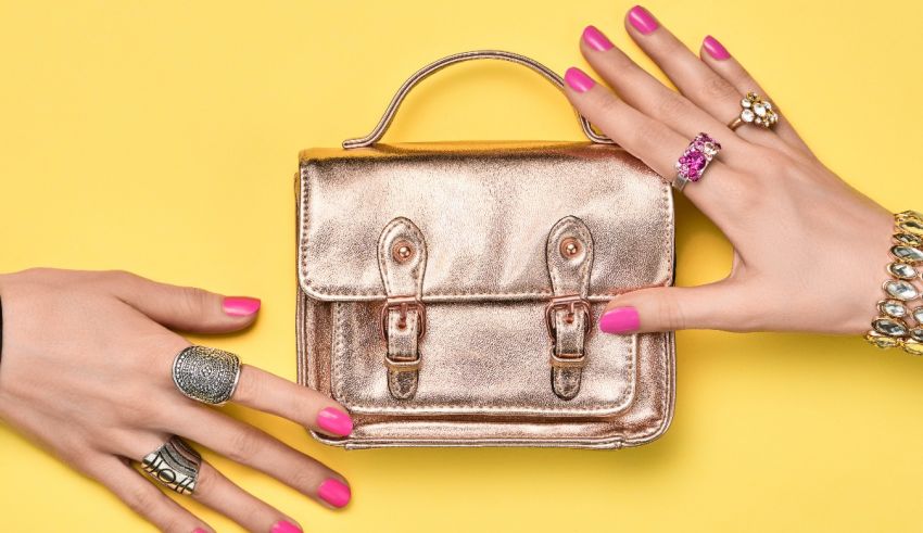 Two women's hands holding a bag on a yellow background.