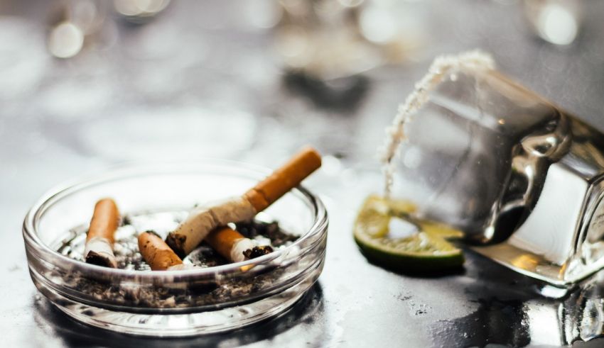 A glass with a cigarette and a glass of water.