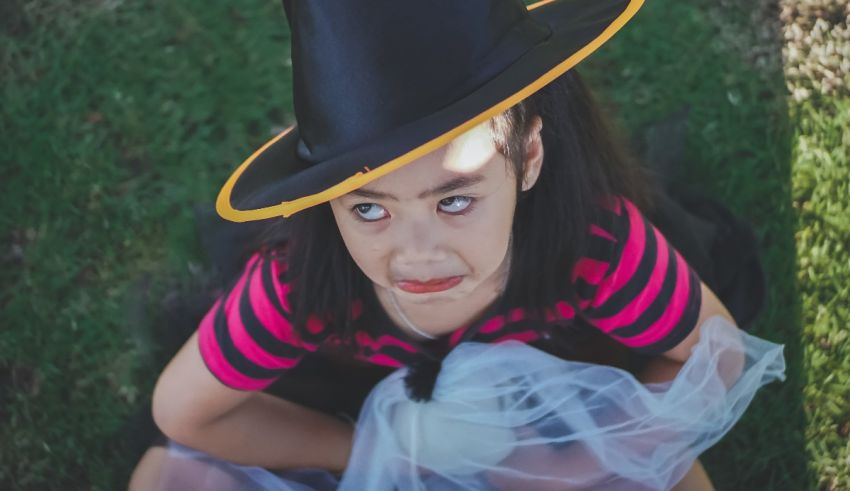 A little girl wearing a witch hat.