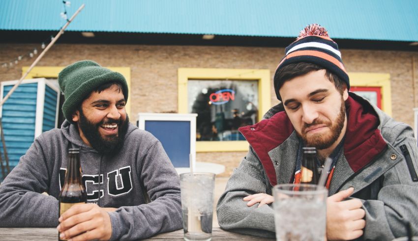 Two men sitting at a table drinking beer.
