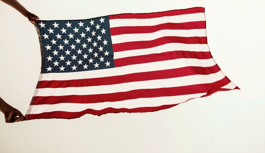 A person holding an american flag against a white background.