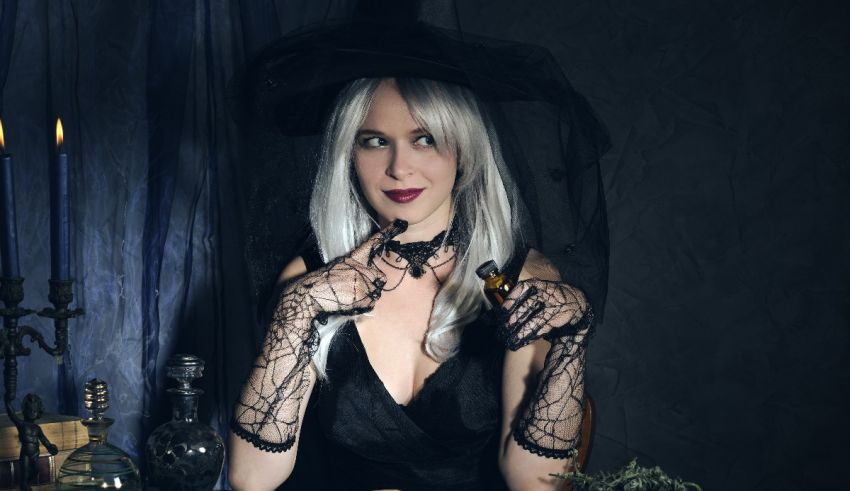 A woman in a witch costume sitting at a table.