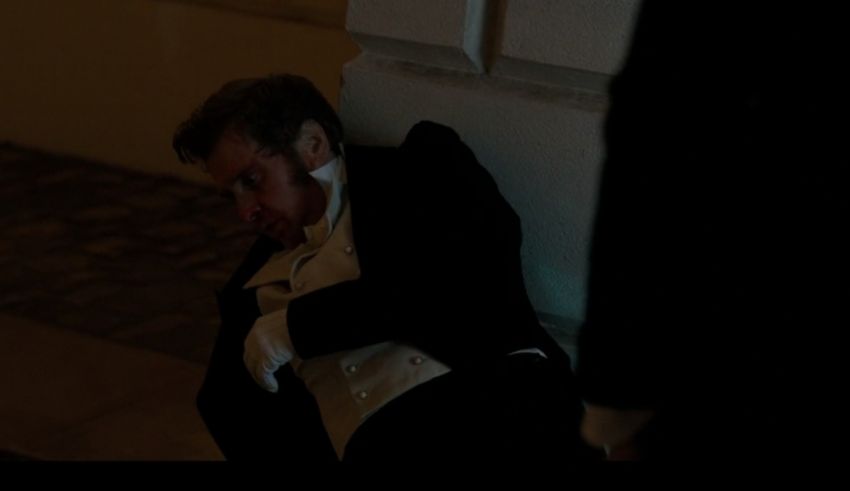 A man in a tuxedo laying on the ground.