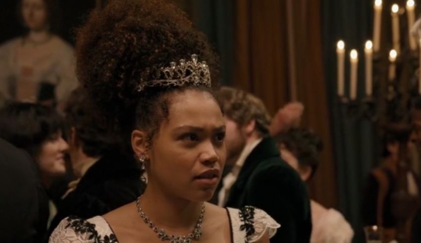 A woman in a dress and tiara standing in a room.