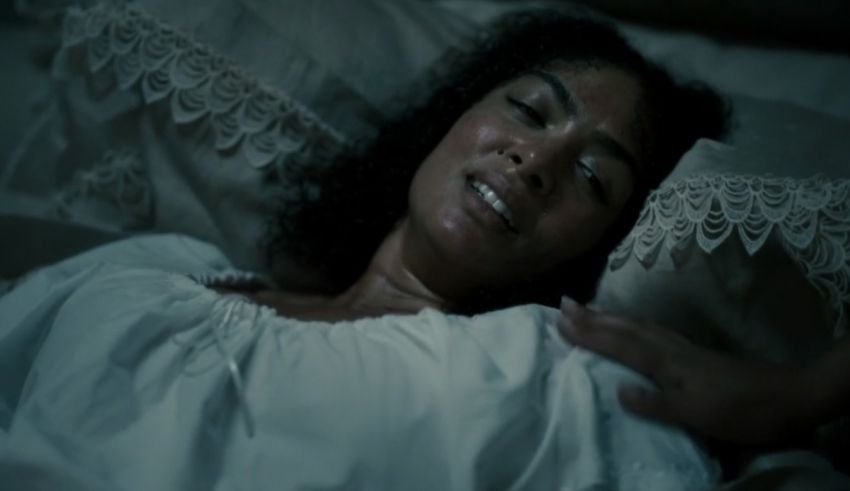 A woman in a white dress laying in bed.