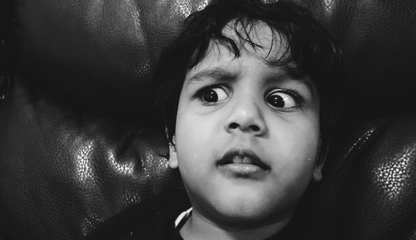 A black and white photo of a young boy staring at the camera.