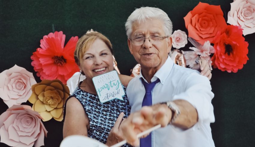 A man and woman posing for a photo in front of a flower wall.
