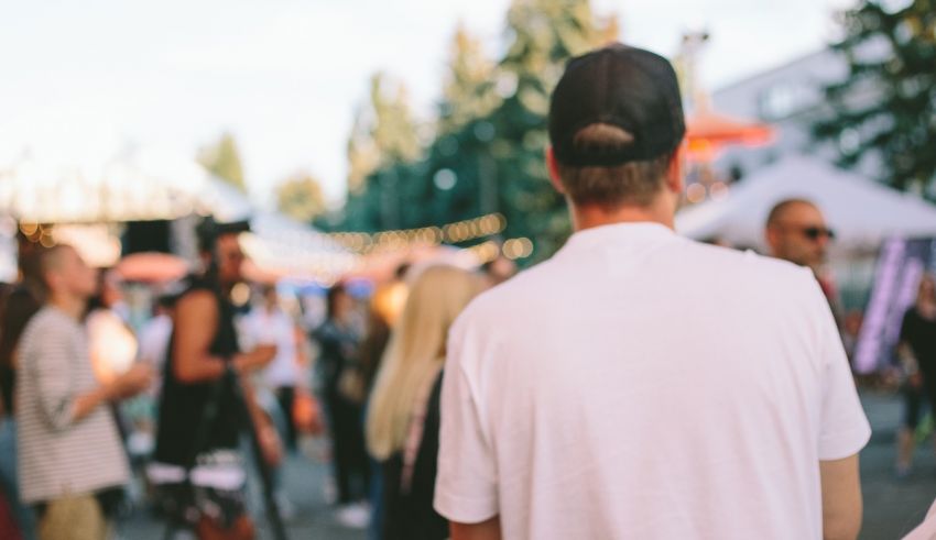 A man walking through a crowd of people at a festival.