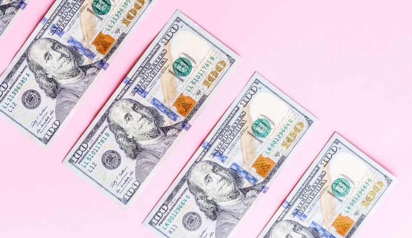 A row of dollar bills on a pink background.