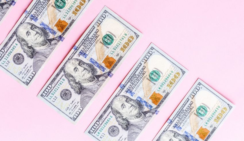A row of dollar bills on a pink background.