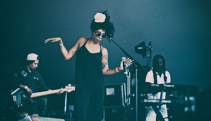 A woman in a black dress singing on stage.