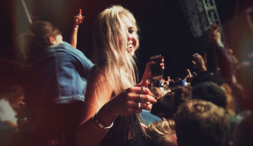 A girl at a music festival with her phone in her hand.