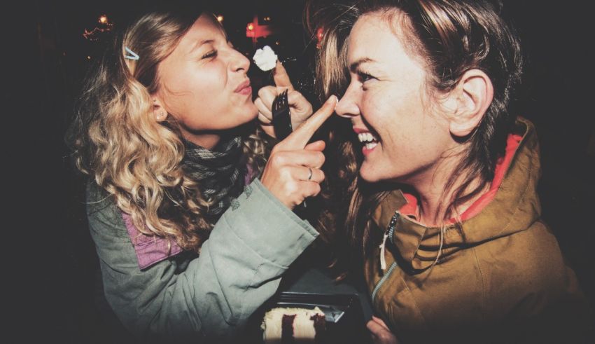 Two women are sharing an ice cream at a party.