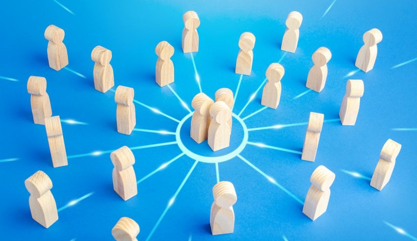 A group of wooden people forming a circle on a blue background.