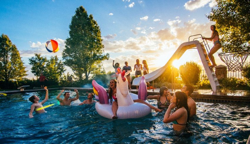 A group of people playing in a pool at sunset.