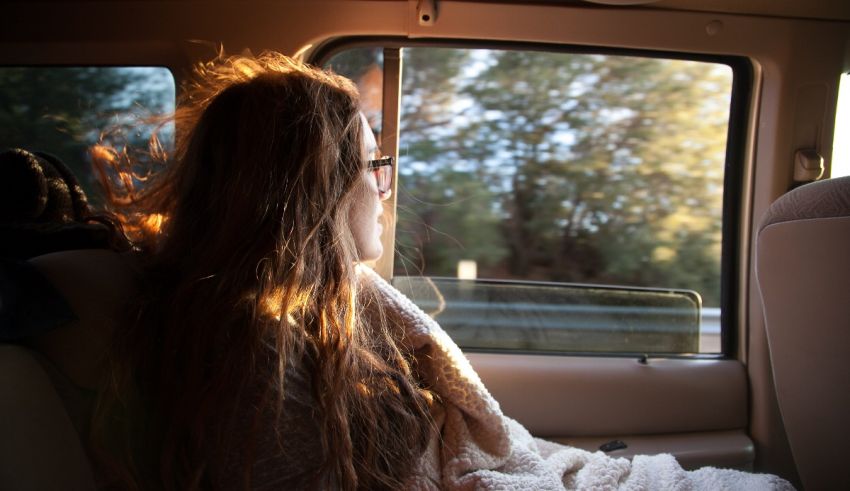 A woman sitting in the back seat of a car.