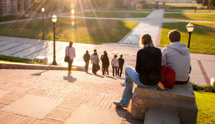 A group of students sitting on steps in front of a building.