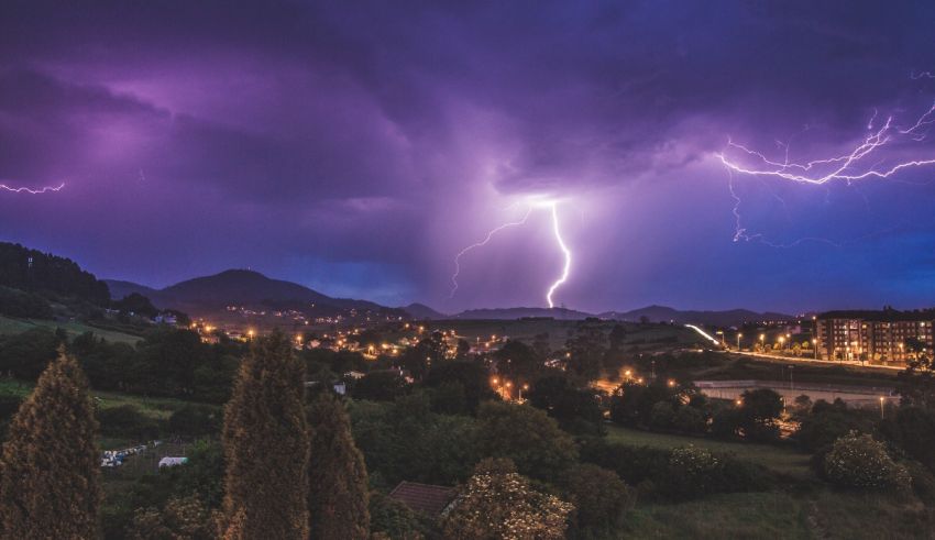 Lightning strikes over a city at night.