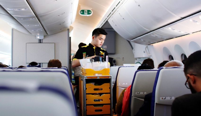 A man is standing in the aisle of an airplane.