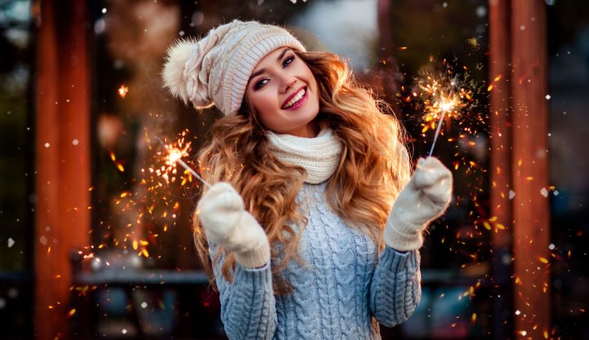 A young woman is holding sparklers in her hands.