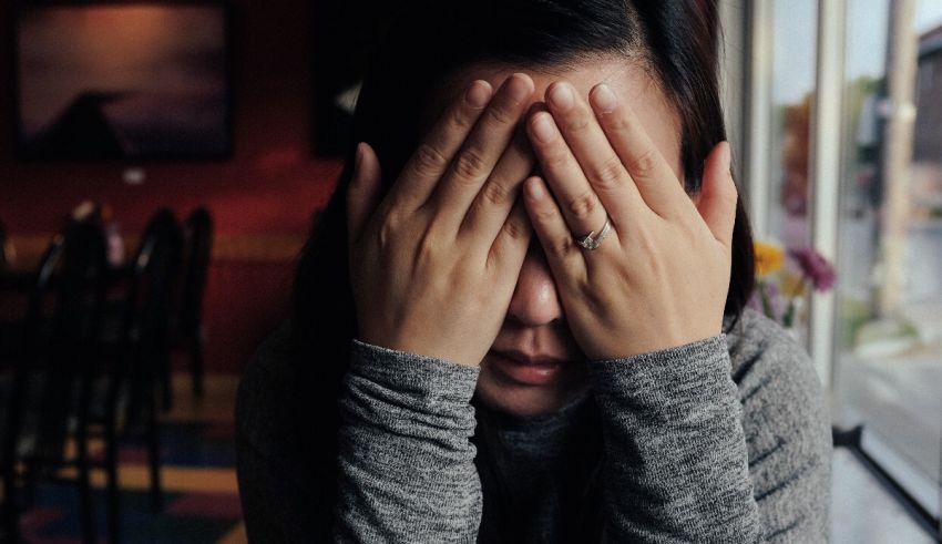 A woman covering her eyes with her hands.