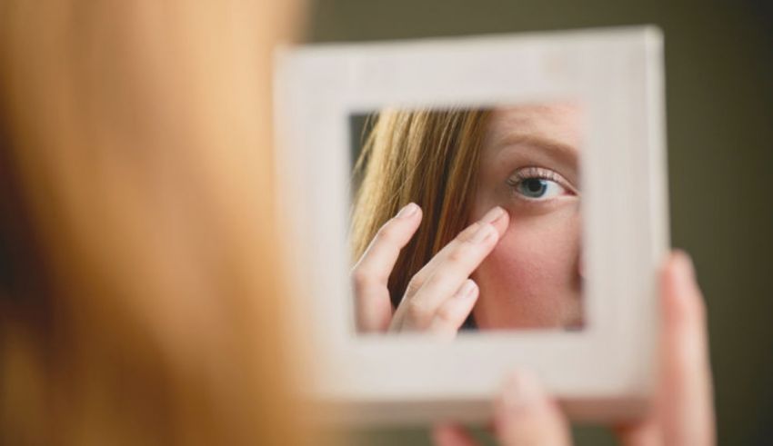 A woman is looking at herself in a mirror.